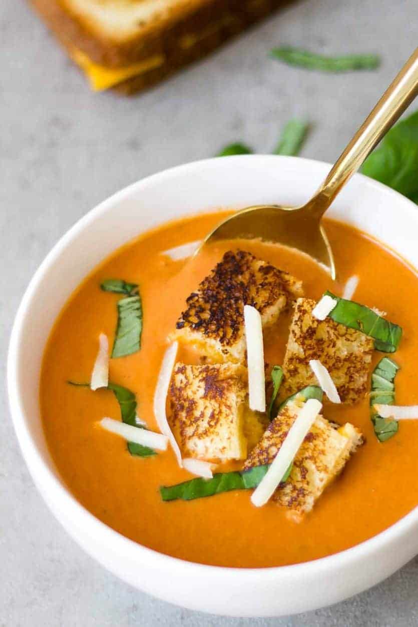 homemade creamy tomato soup in a bowl with grilled cheese croutons