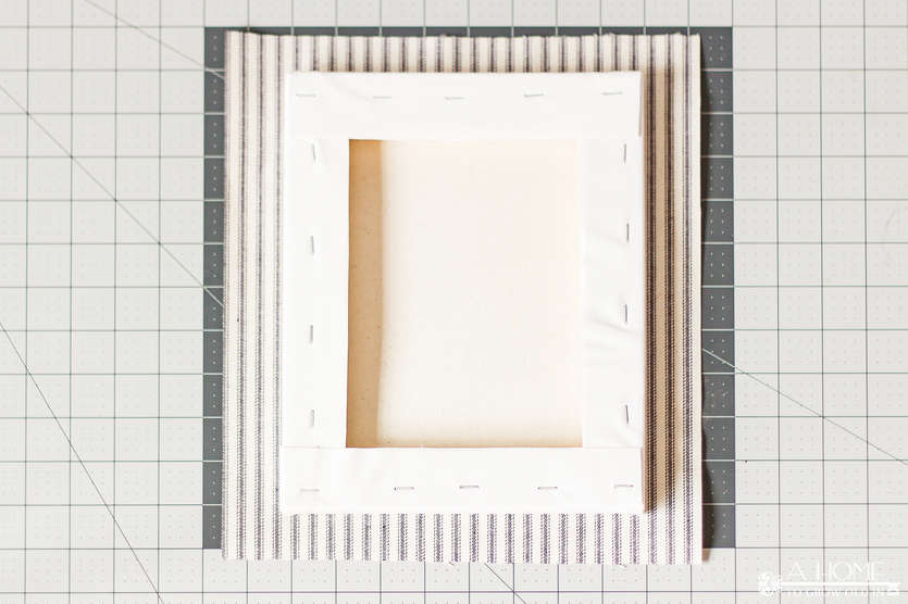 cutting fabric to wrap a canvas