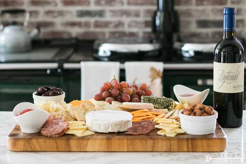 cheese board with wine in the background