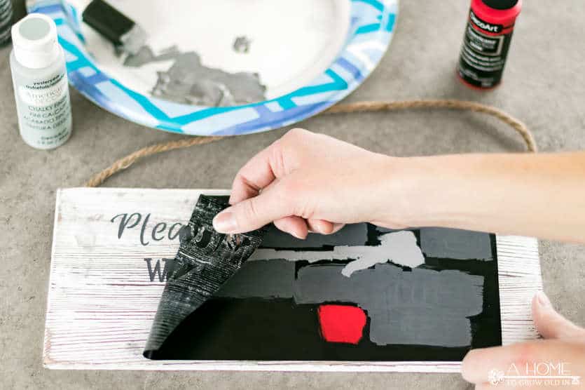 peeling vinyl off painted wooden sign