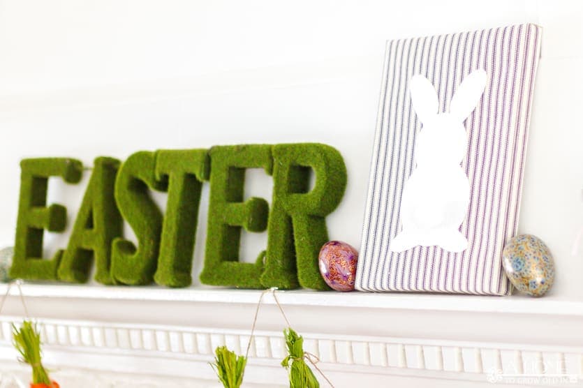 fireplace mantel decorated for spring or Easter with a DIY fabric wrapped bunny canvas