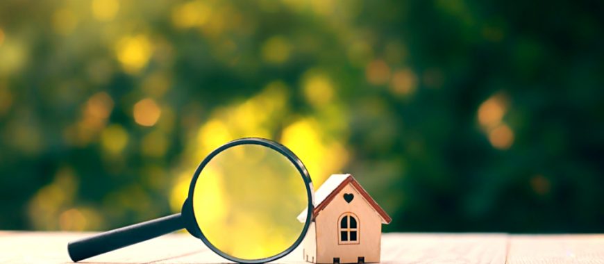 magnifying glass in front of small house