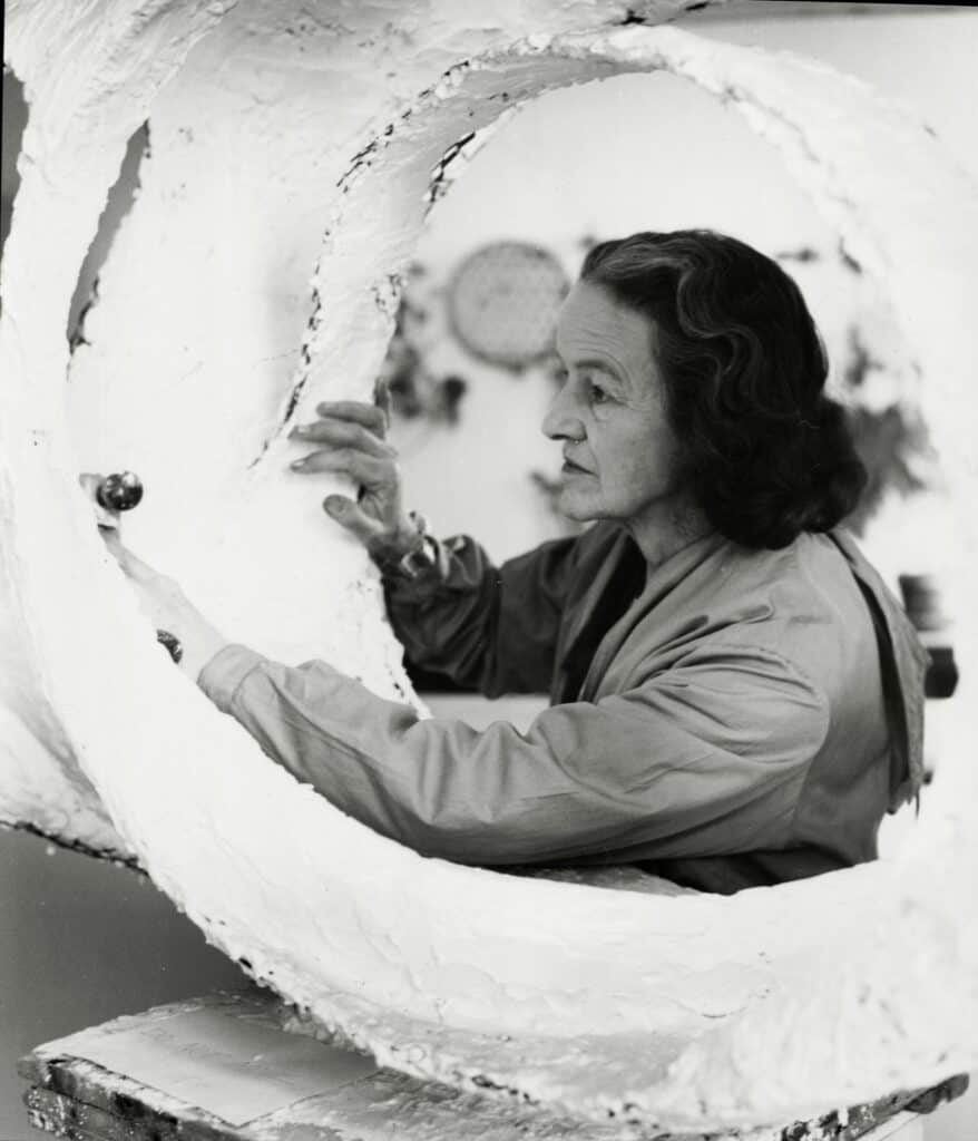 Hepworth at work on the plaster prototype for Oval Form (Trezio) in her Palais de Danse studio, St Ives, 1963. Photograph by Val Wilmer.
Courtesy Bowness. Barbara Hepworth © Bowness.