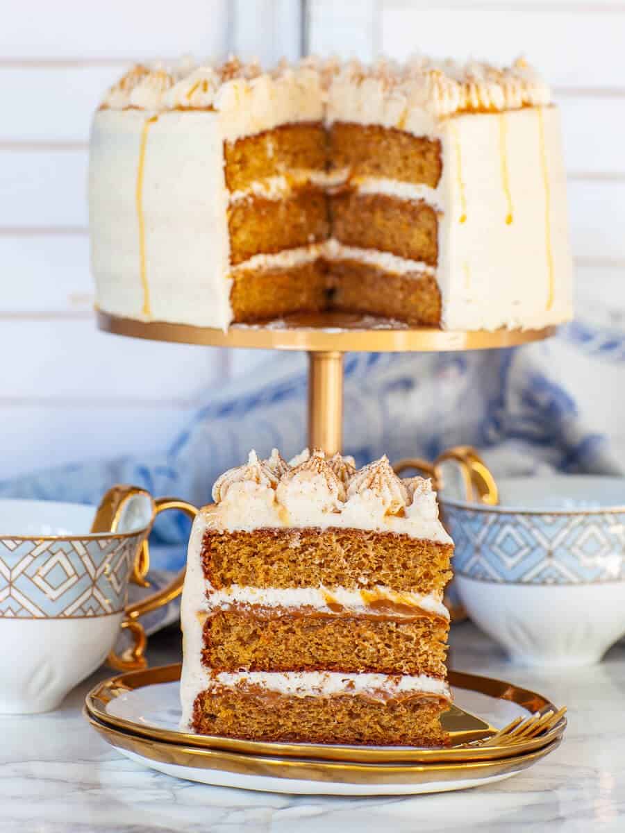 cinnamon roll cake slice with cream cheese frosting and caramel filling