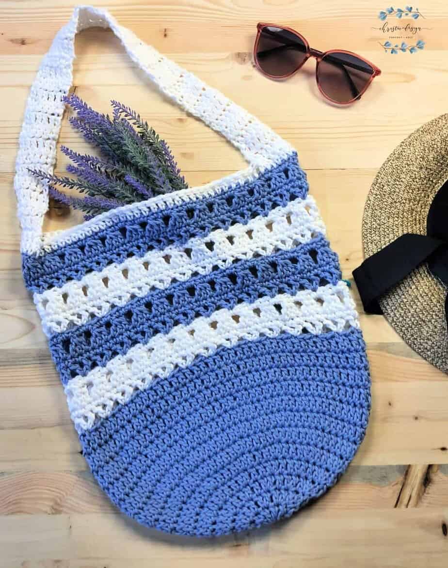 picture of violet striped free crochet market tote pattern flat with glasses and hat flat lay