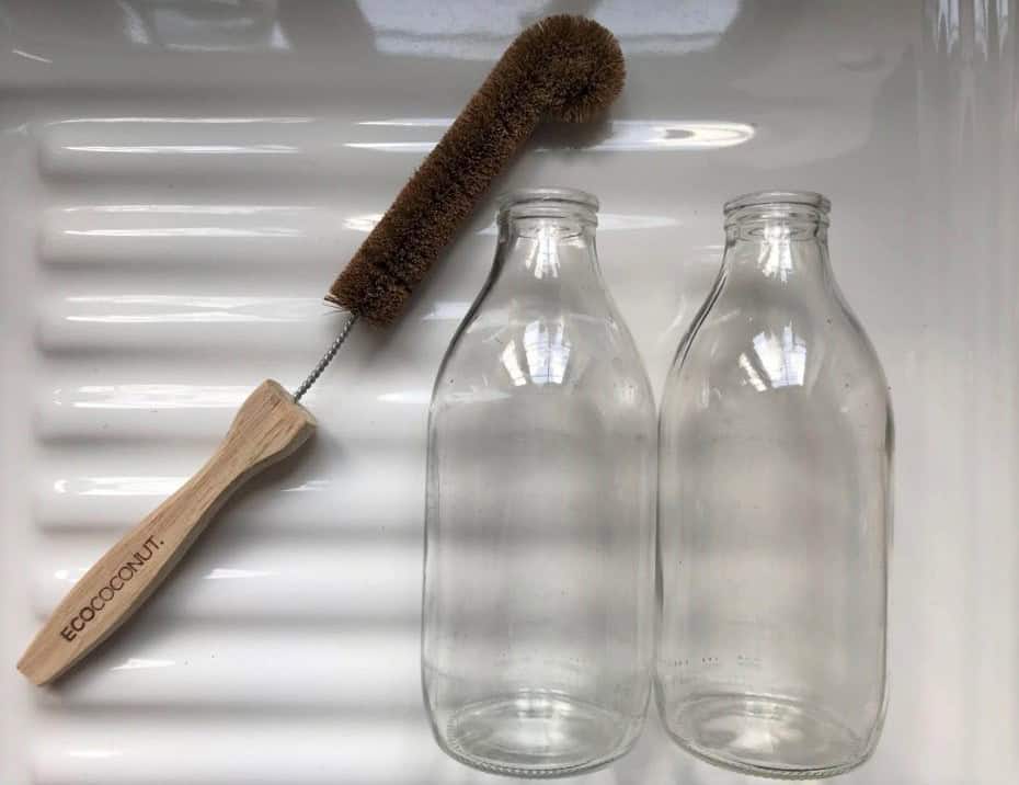 the ecococonut bottle brush laying next to 2 empty milk bottles