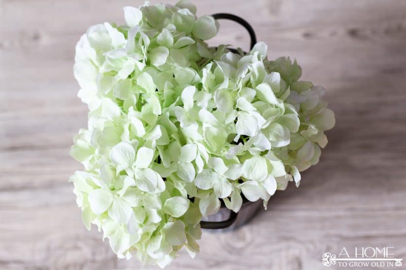 This spring floral door hanger is so easy to do and requires no floral arranging skills! A flower arrangement is a fun alternative to a wreath! Plus, I love the galvanized bucket!