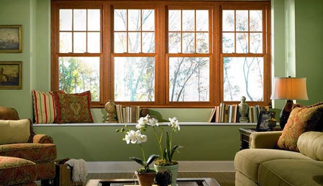 single sliding windows Single hung sliding windows, brown wood frames, set in green living room
