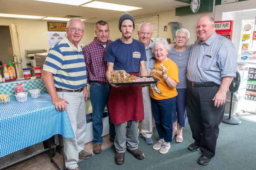 The southern Maryland stuffed ham tradition is supported by folks like, from left, Ray Raley, Matt Bowes, Samuel Pratt, Dan Raley, Carla Tomaszewski, Pat Bowes, and David Dent, pictured here at WJ Dent & Sons country store in Tall Timbers, St. Mary's County. Photo: Edwin Remsberg Photographs