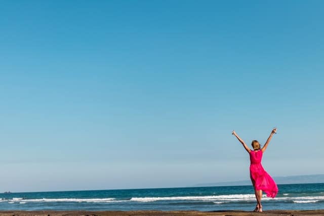 uma mulher com um vestido vermelho de pé na costa