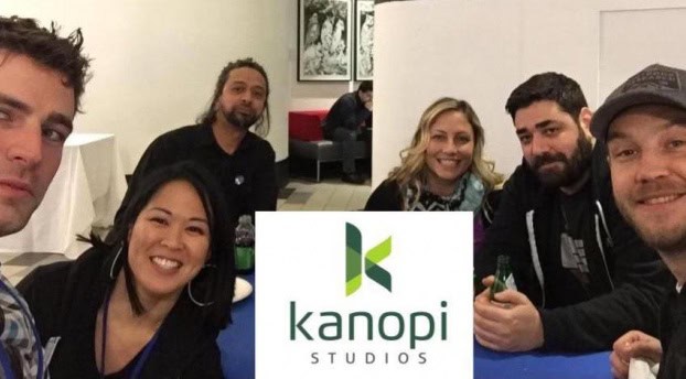 Photo of Kanopi employees smiling, with the Kanopi logo in the center.