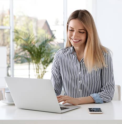 Woman-Looking-At-Laptop-Smiling-2 Woman looking at laptop smiling 2