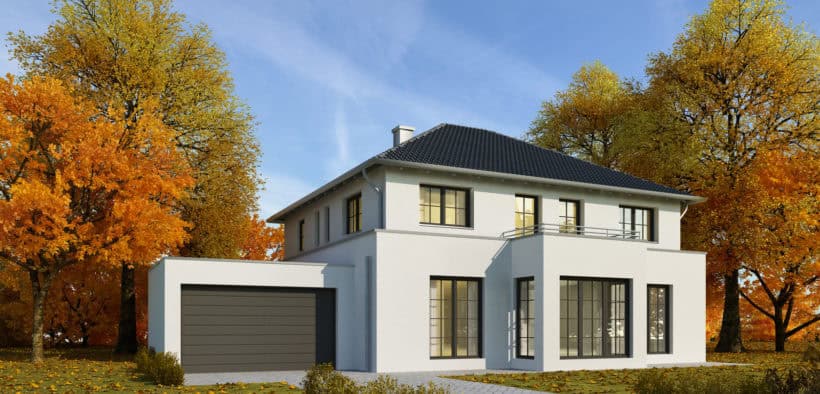 Walmdach auf einem modernen Haus, umringt von herbstlichen Bäumen