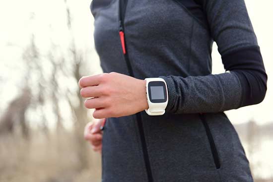 Fitness tracker on wrist of female jogger