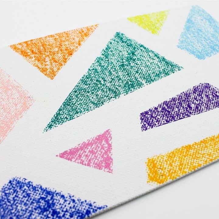 square image of white canvas board with oil pastel design