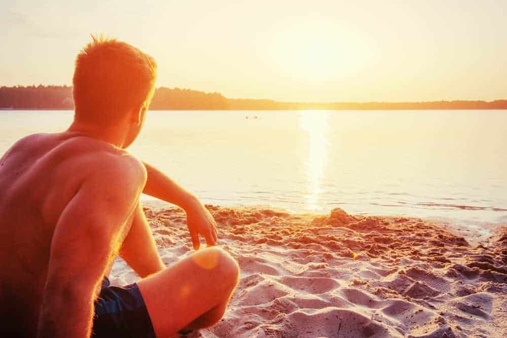Man sits on the beach. Contemplates coping skills A man sits quietly on the beach reviewing his coping skills to cope with relapse and recovery.