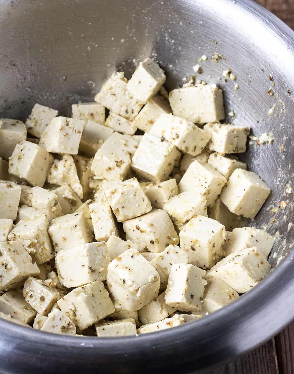 seasoned tofu cubes for vegan feta cheese in a silver bowl