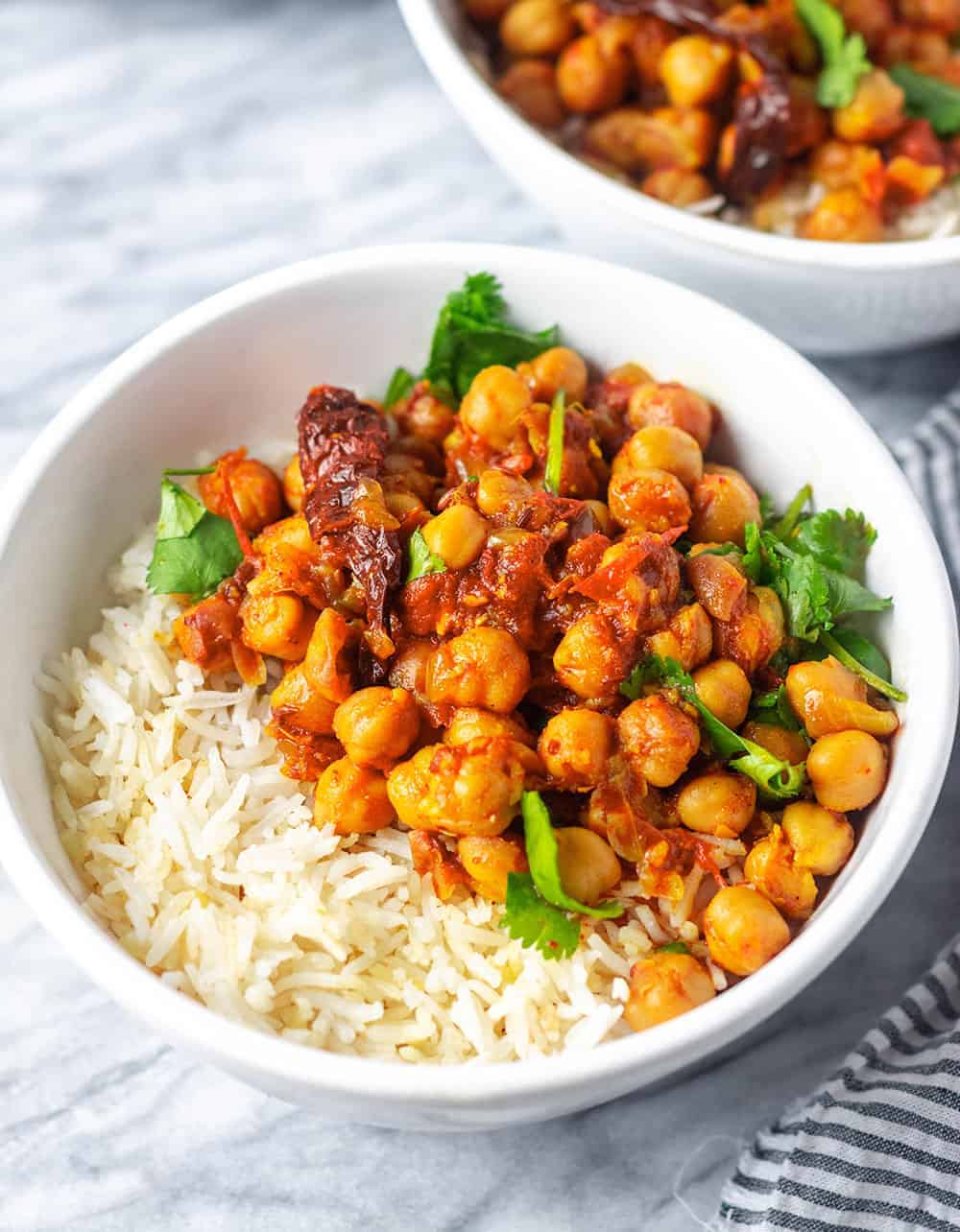 chana masala in a two white bowls on white background