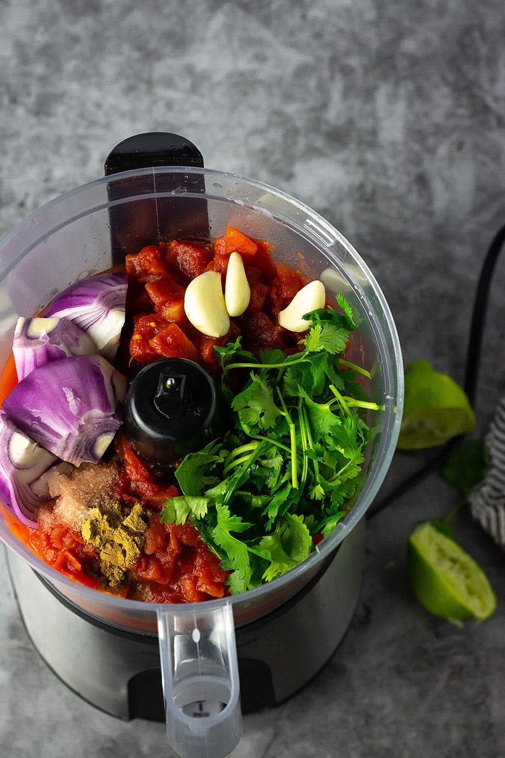 Ingredients for simple salsa in the bowl of a food processor