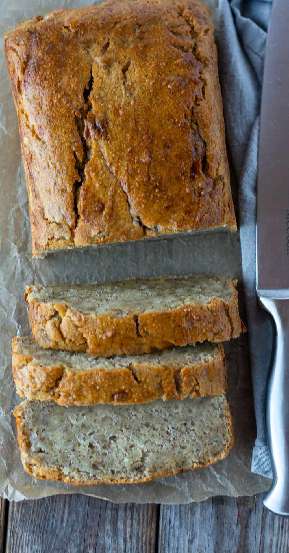 Vegan Gluten-Free banana bread cut in slices with over head shot, gray towel and knife