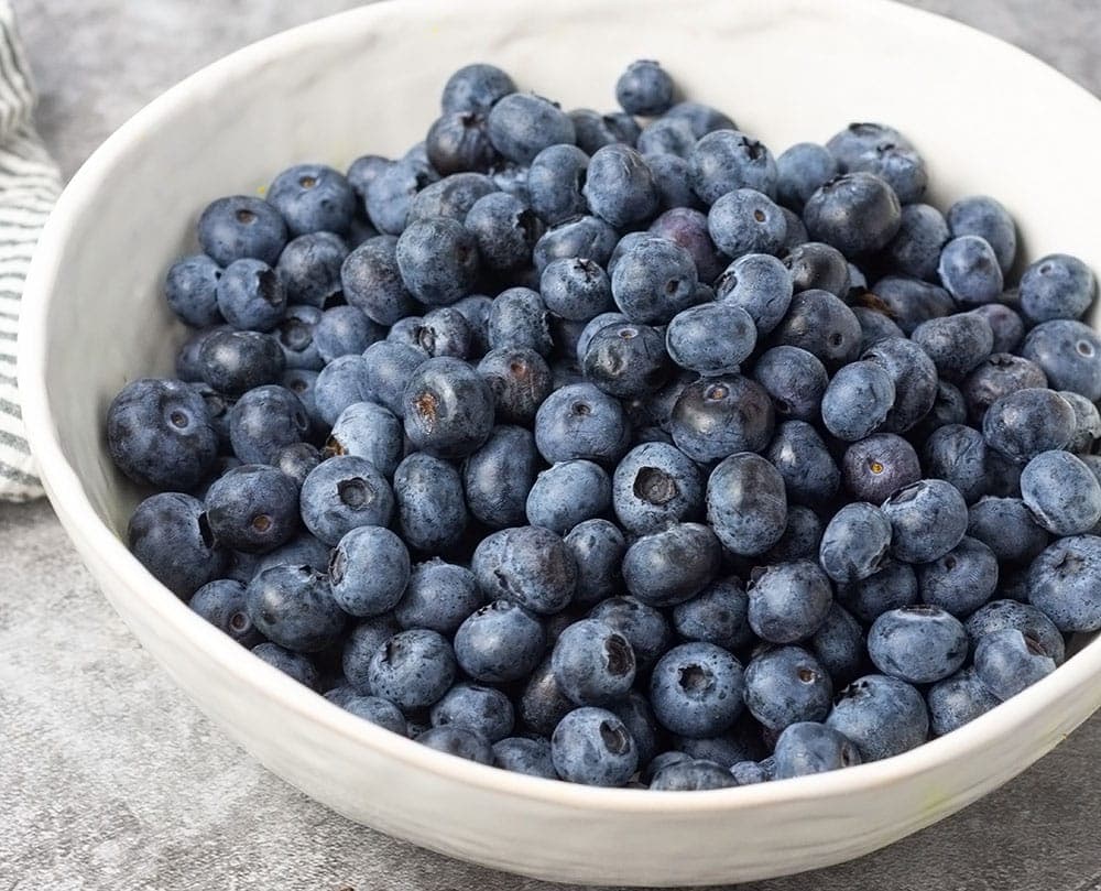 Blueberries in a white bowl for blueberry cake