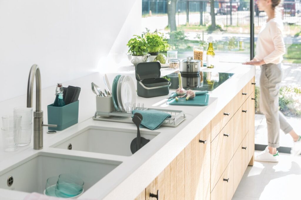 cucina senza pensili, in rovere e top bianco con utensili per pulizia