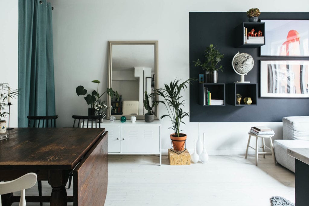 credenza bianca con specchio appoggiato sopra per organizzare una casa piccola