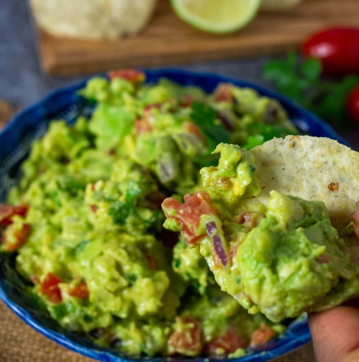 A scoop of loaded guacamole in a blue bowl