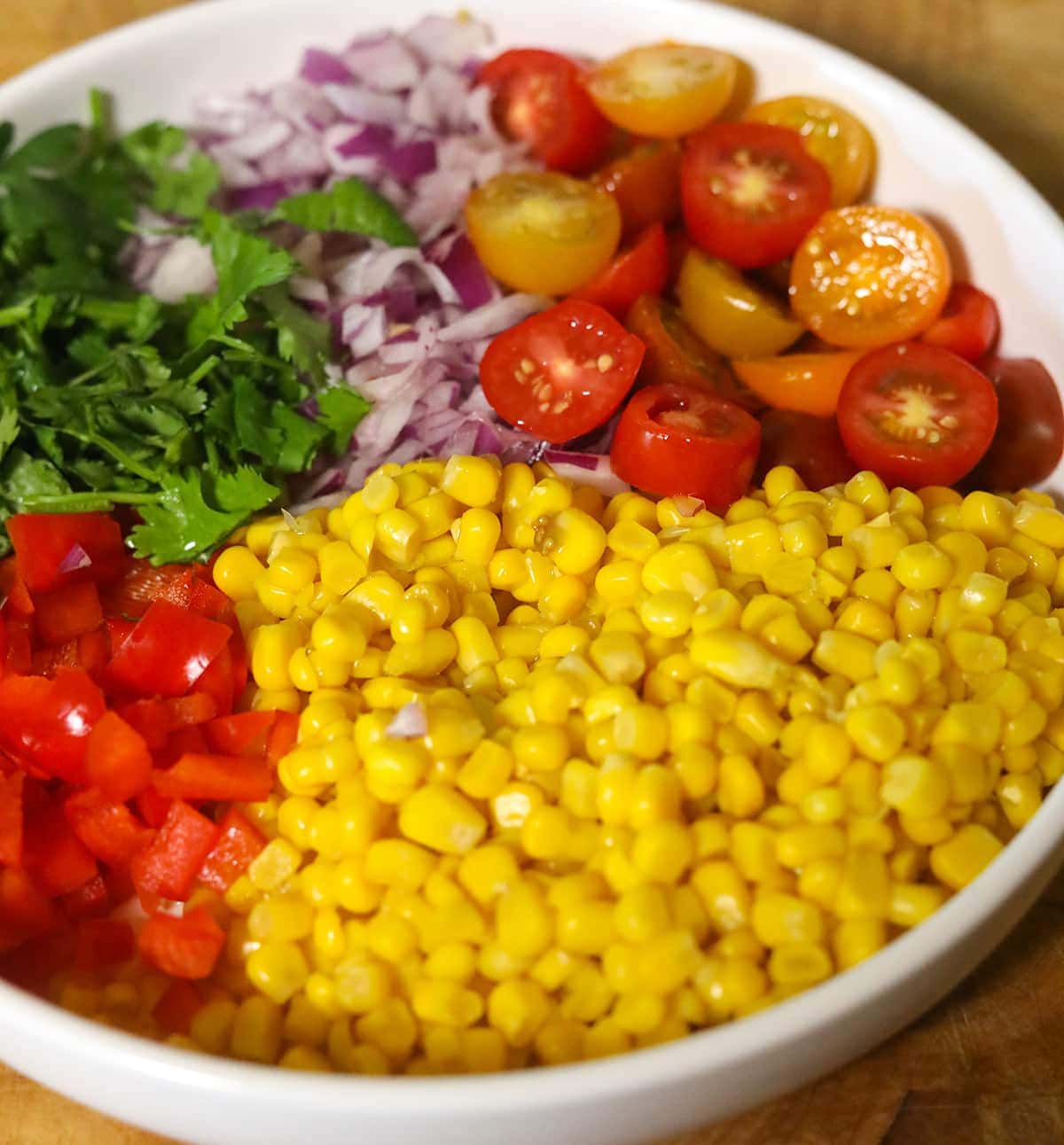 Ingredients for Mexican corn salad in a white bowl