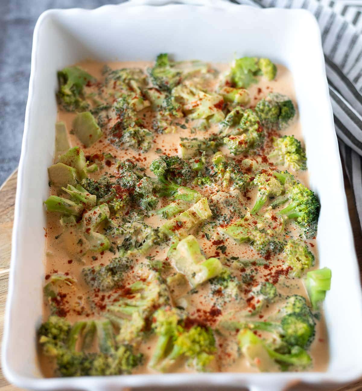 broccoli cheese casserole in white casserole dish before baking