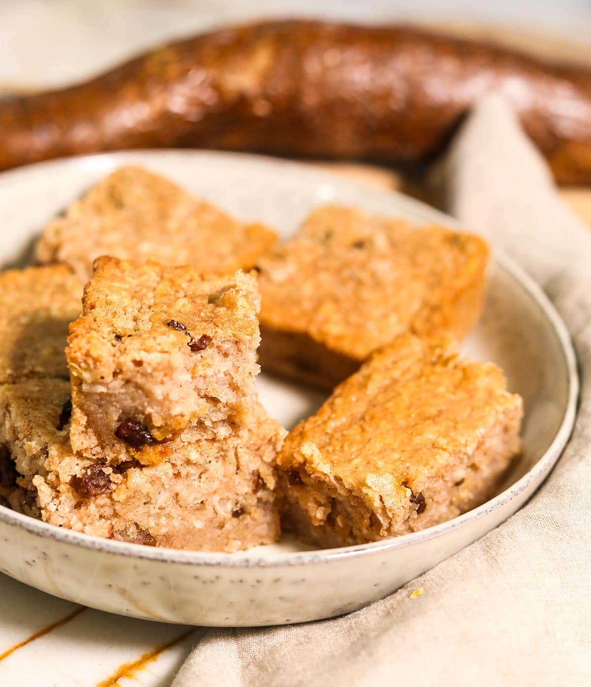 Cassava pone slices in a beige bowl with cassava in the background