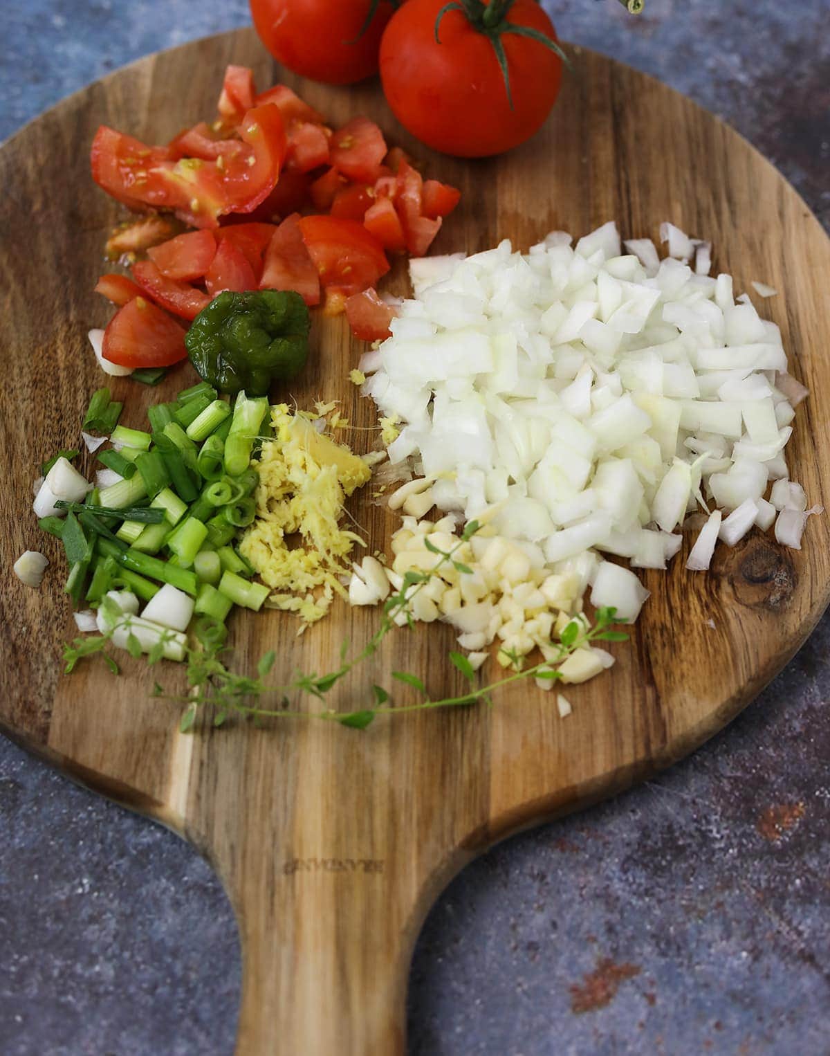 Ingredients for kidney bean curry on a wooden board on blue background
