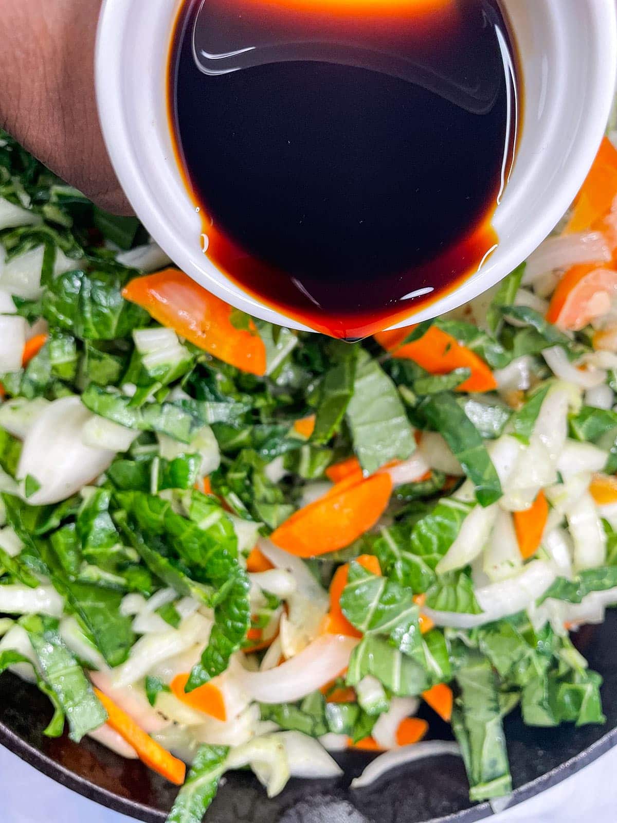 chop suey cooking and pouring tamari over it.