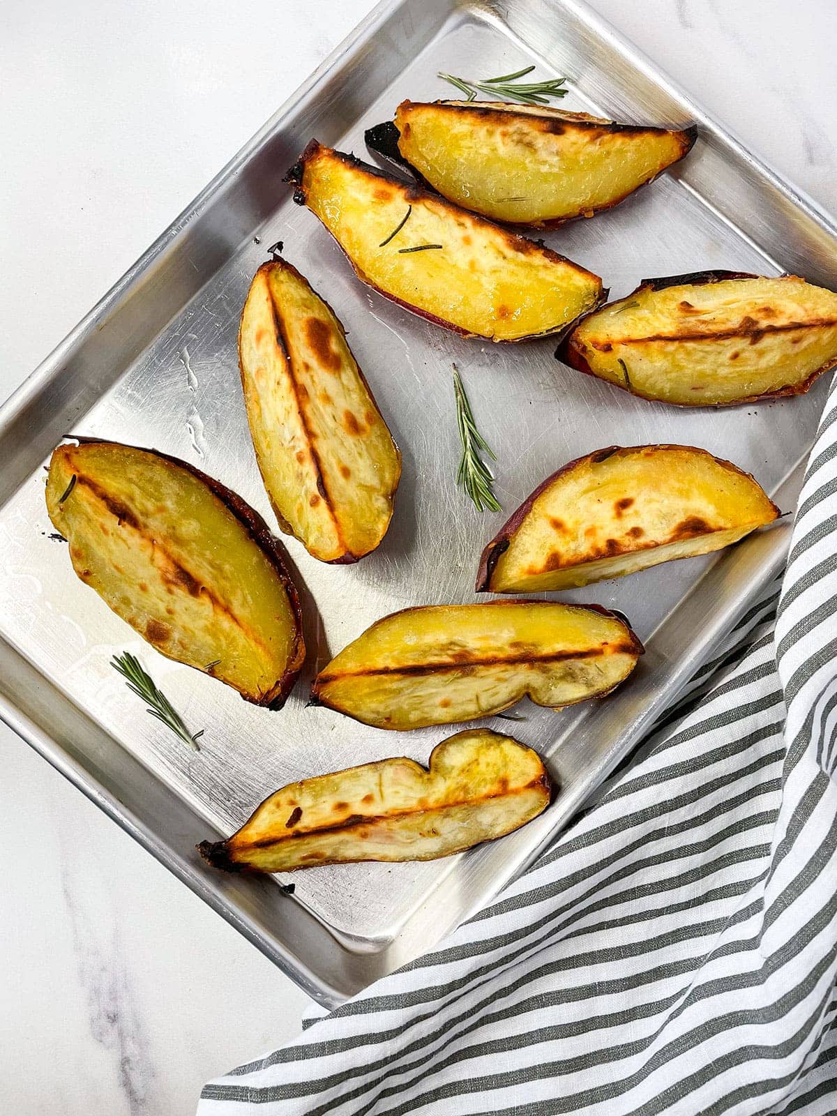 overlay of baked white sweet potatoes on a baking tray