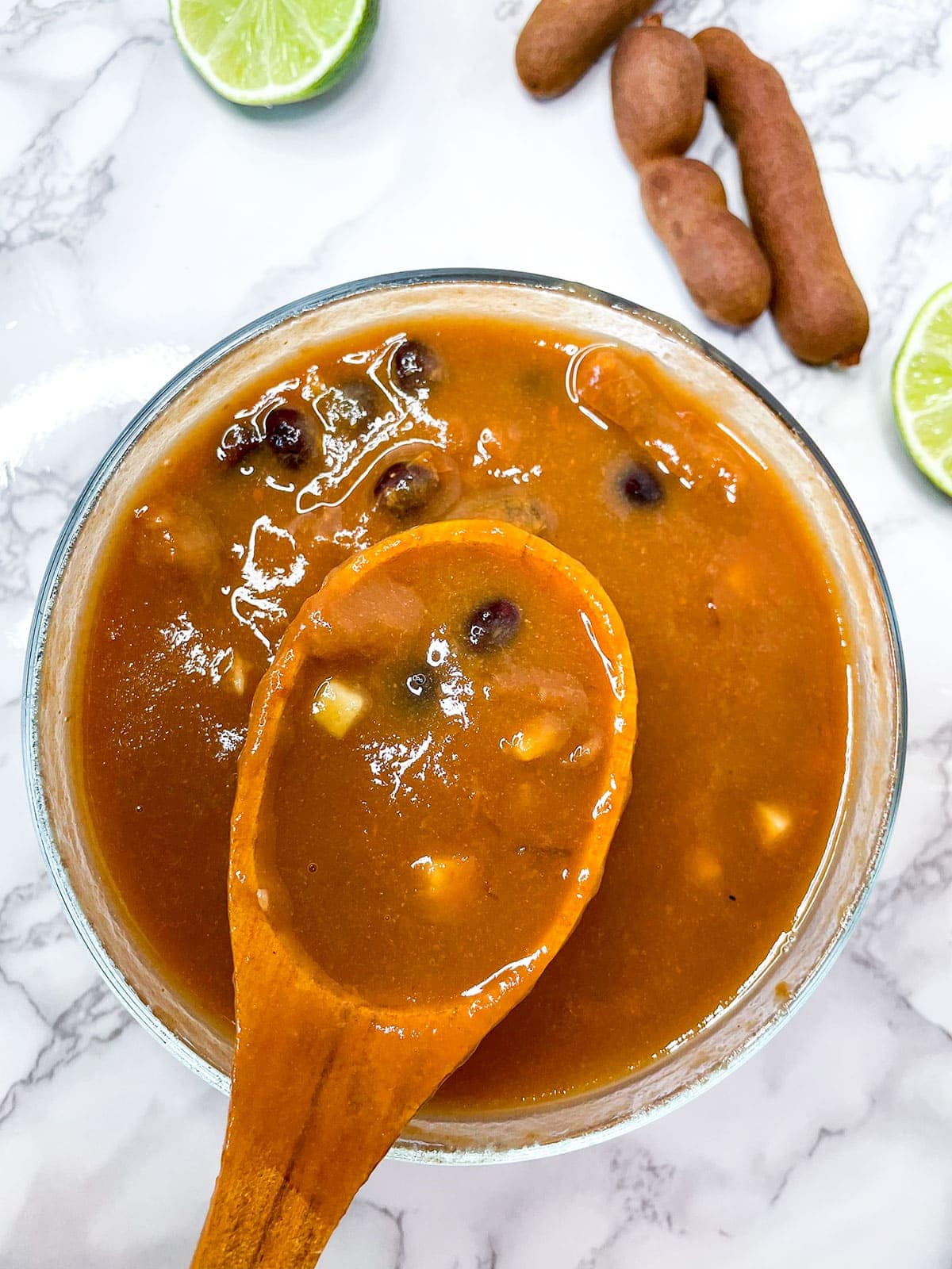 tamarind pulp removed from seeds with a spoon in a bowl on a white background