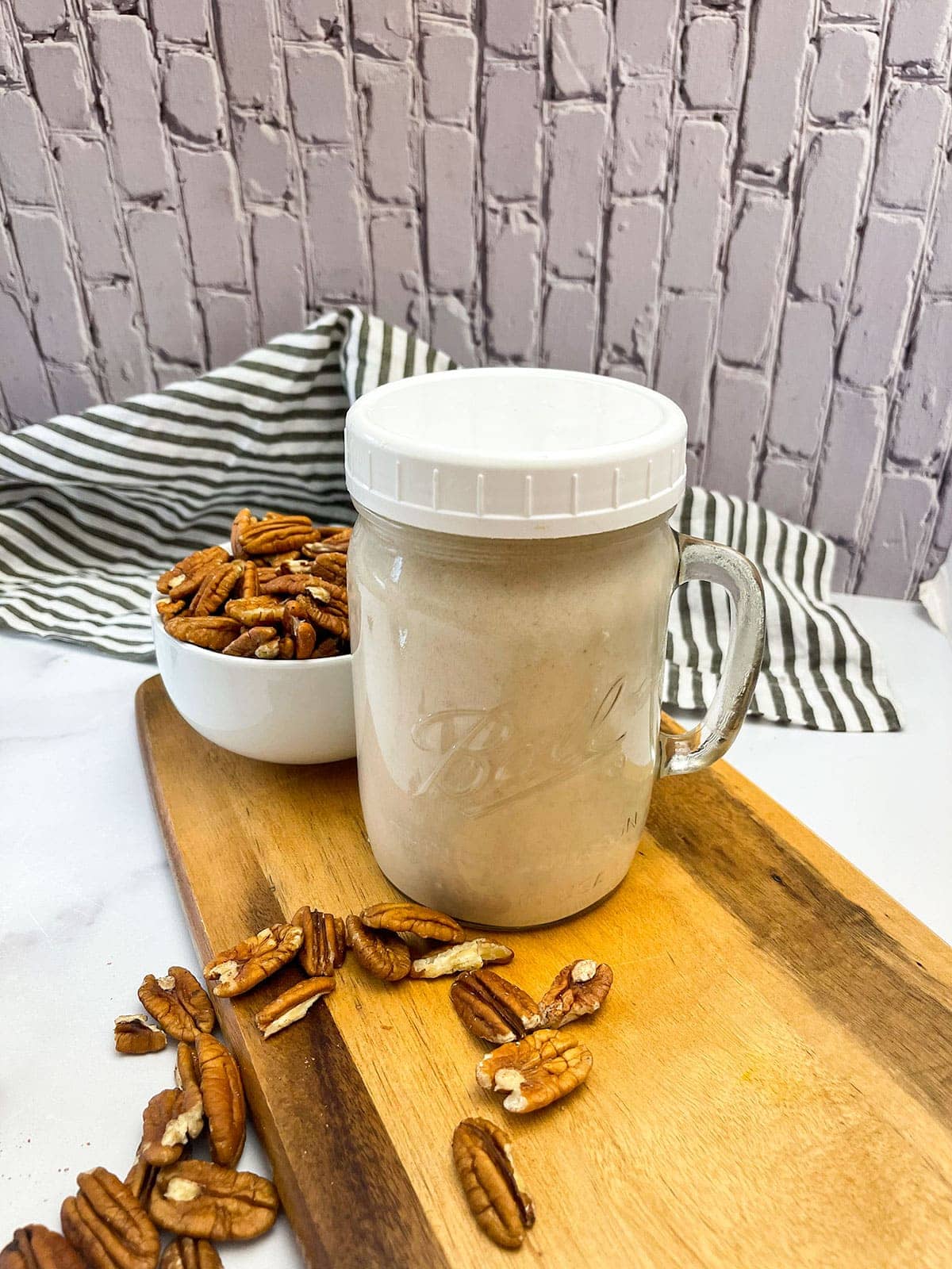 Pecan milk in a glass jar on a cutting board