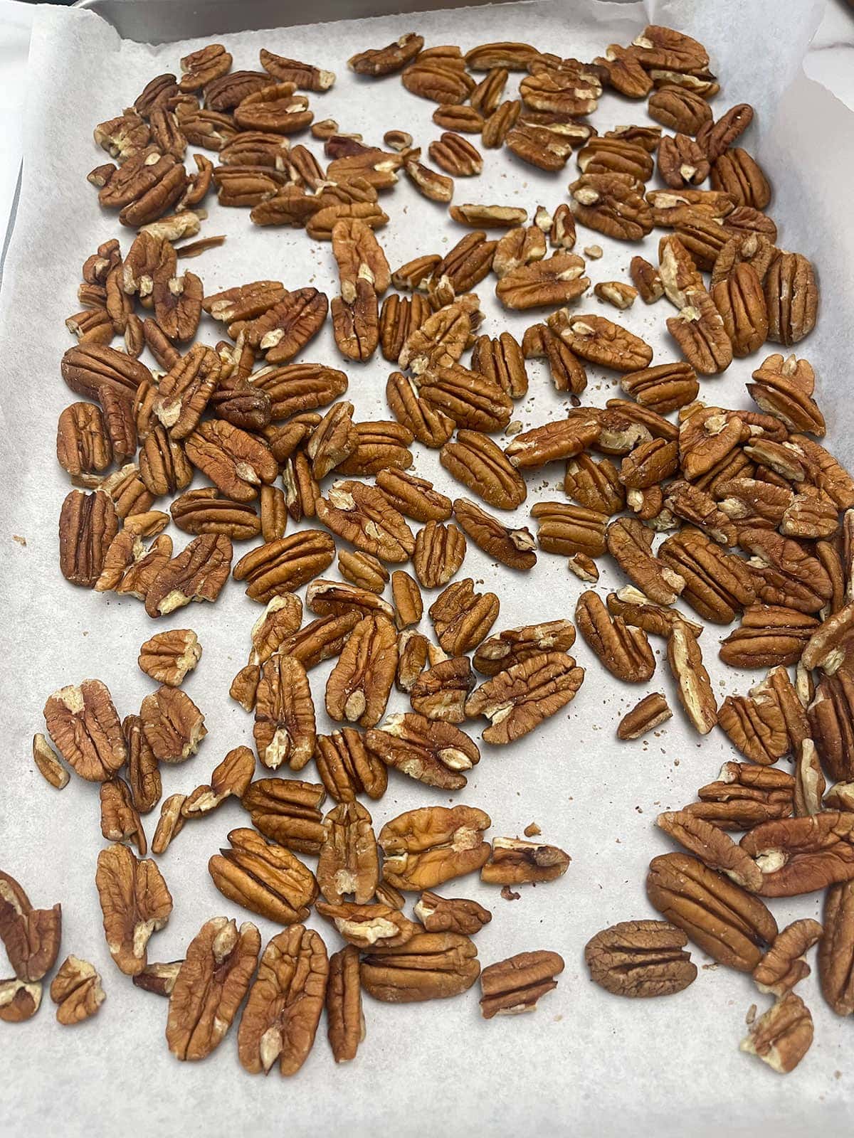 pecans on a baking sheet about to get toasted