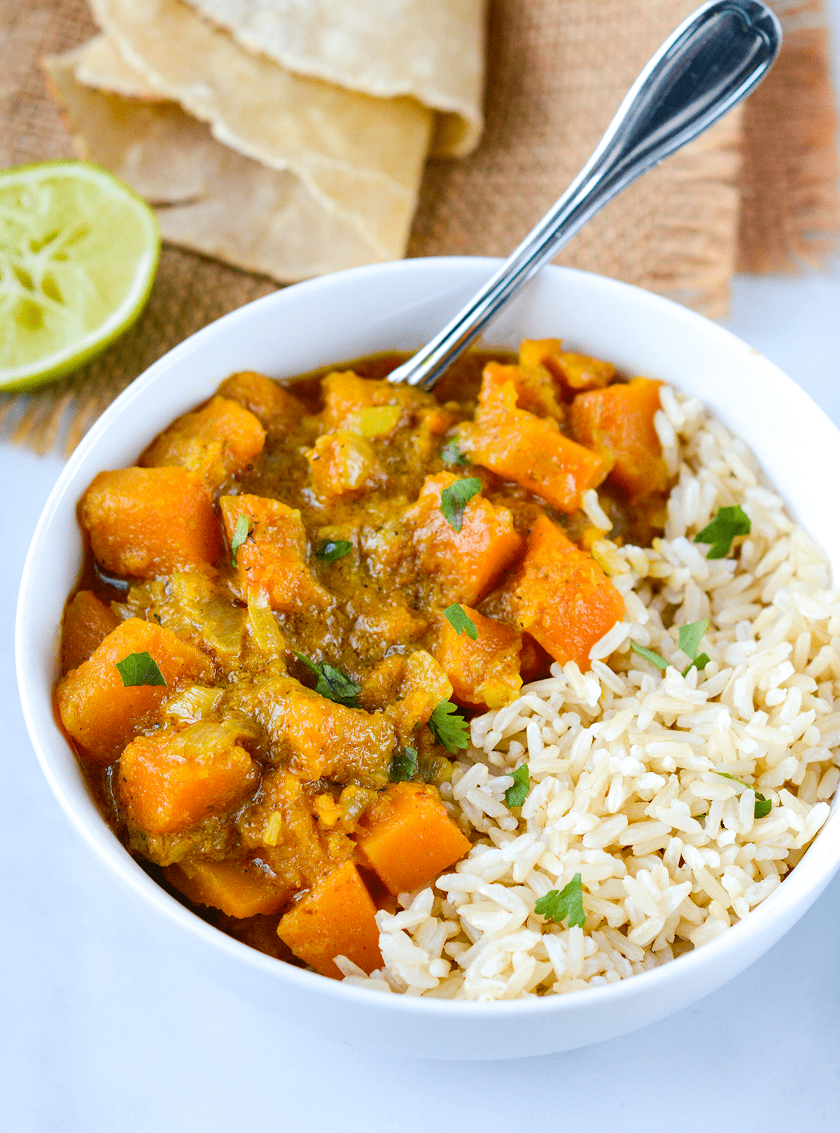 butternut squash coconut curry in a white bowl on a white background