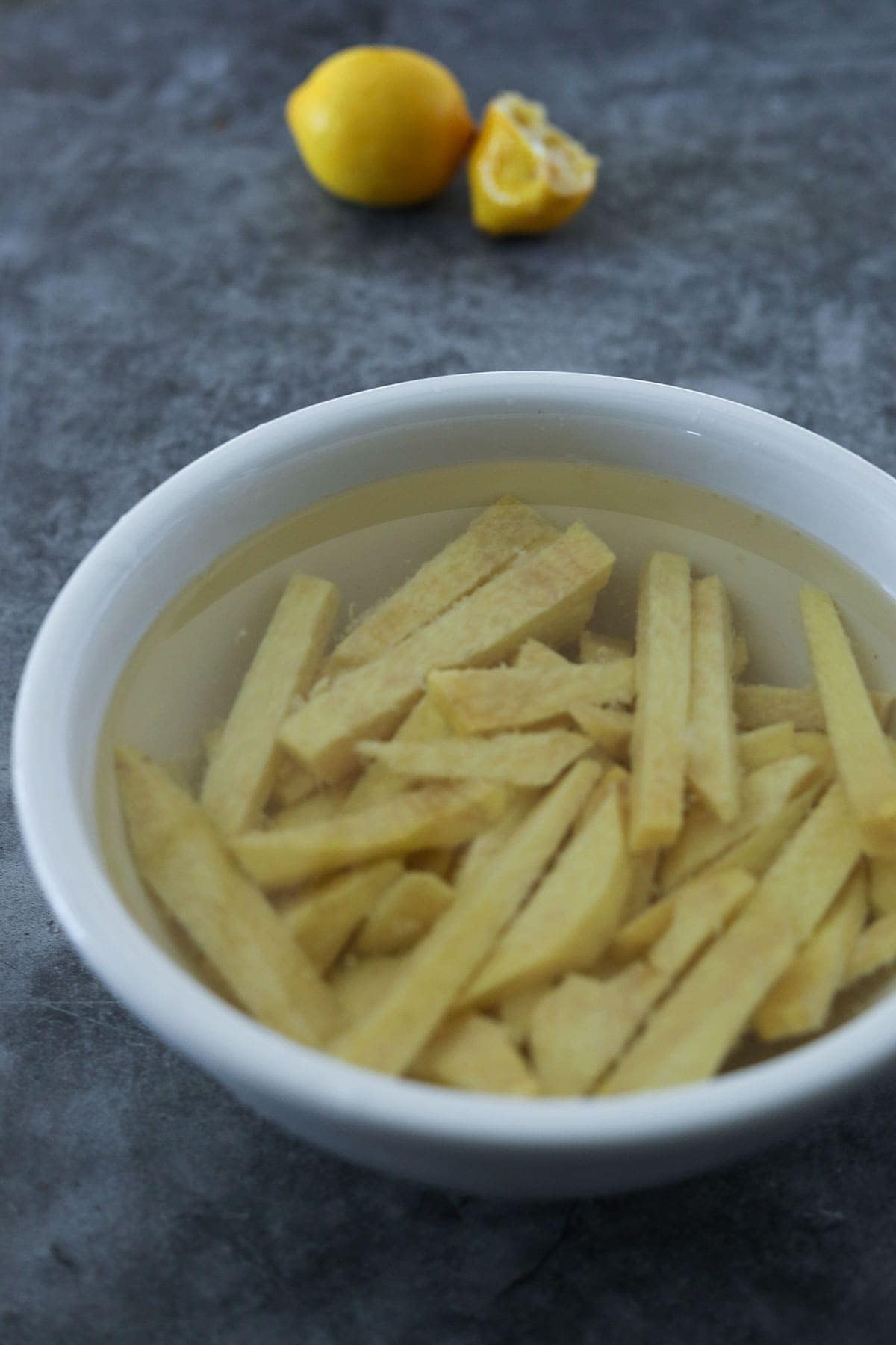yam cut into match sticks for fries, soaking in lemon water