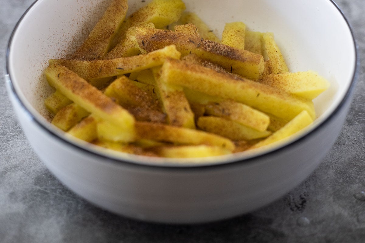 seasoned yellow yam fries in a white bowl