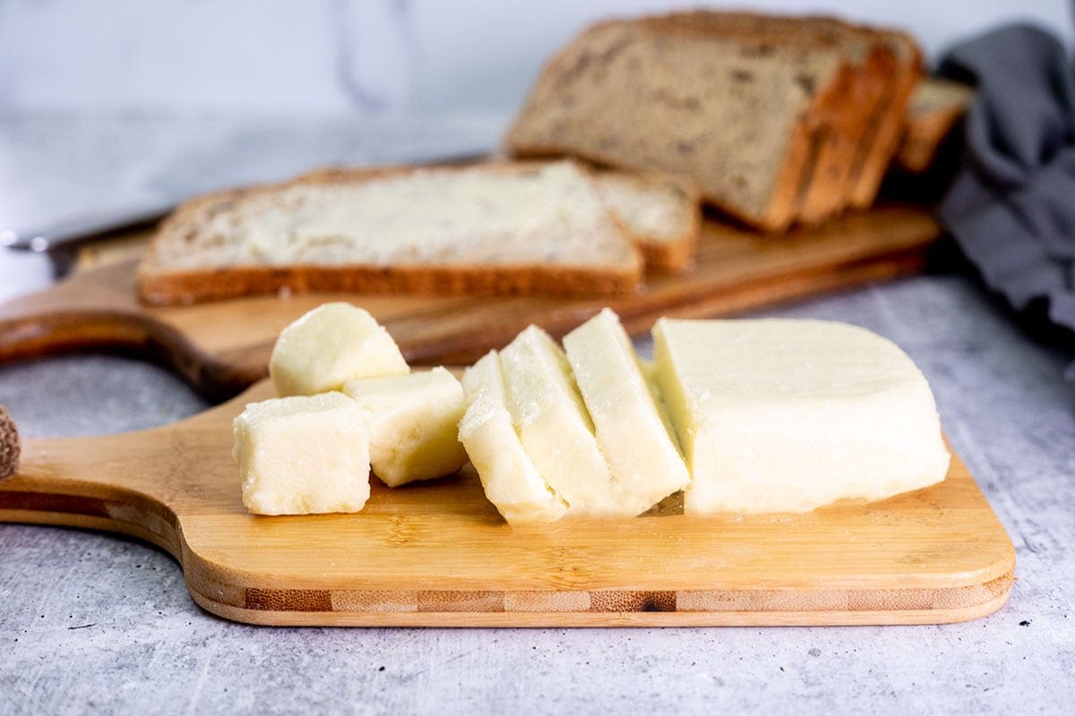 vegan butter on a cutting board with bread in the background
