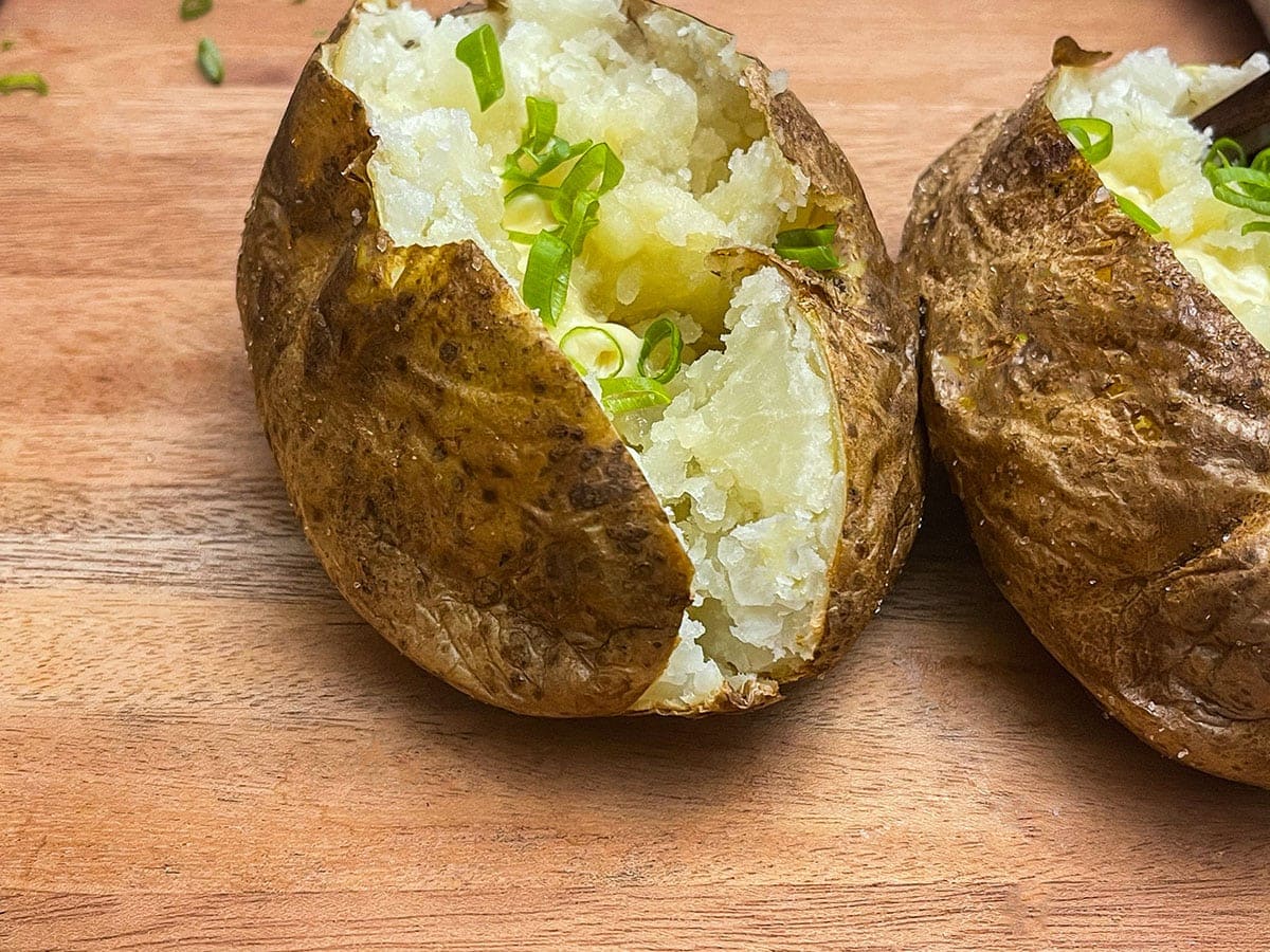 close up baked air fried potatoes on a wooden cutting board