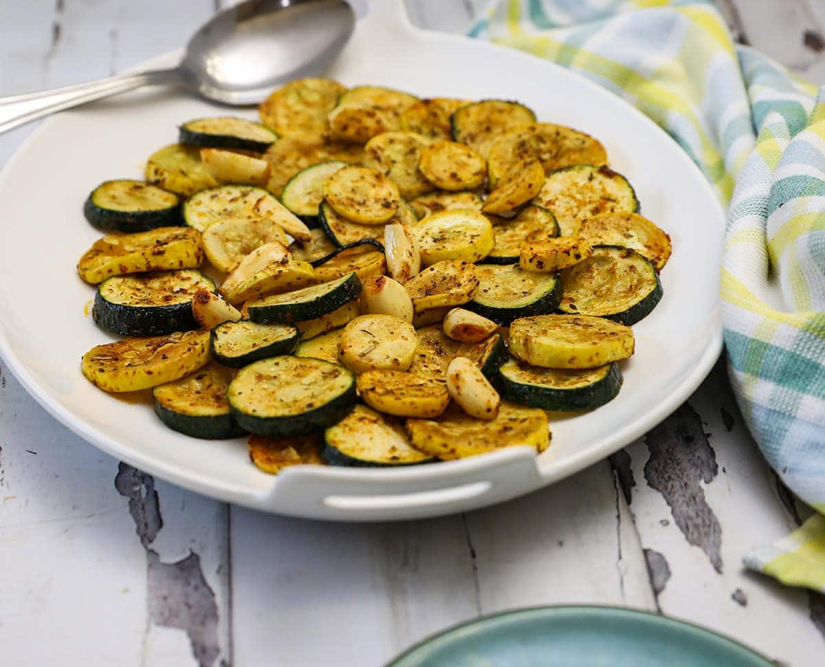 oven roasted zucchini and yellow squash on a white platter on a white background