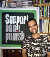 Dor from SSDP Israel standing in front of a Support Don't Punish poster.