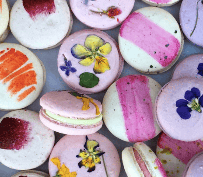 A pretty assortment of pink and cream macarons with edible flowers and artistic finishes, available only at Sweet Maresa's. Kingston's hidden gem, with vegan, handmade desserts using ethically sourced ingredients.