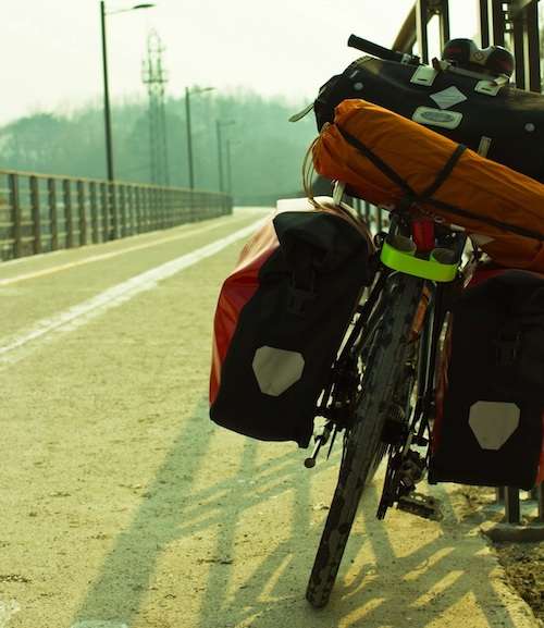 Rear view of a touring bike parked on a bridge, with wide tires