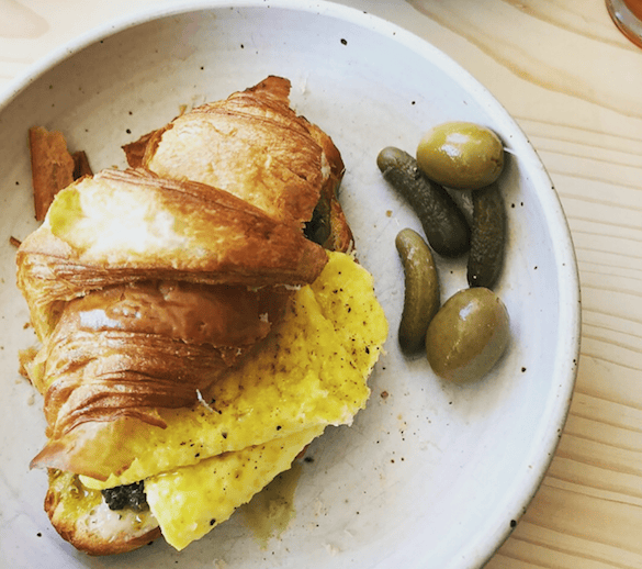 A wholesome breakfast croissant filled with neatly folded eggs and a side of crunchy mini pickles, a go-to at Village Coffee & Goods in Kingston, NY. A local favorite, VCG is a specialty coffee shop serving breakfast and lunch + selling provisions and goods by local makers.