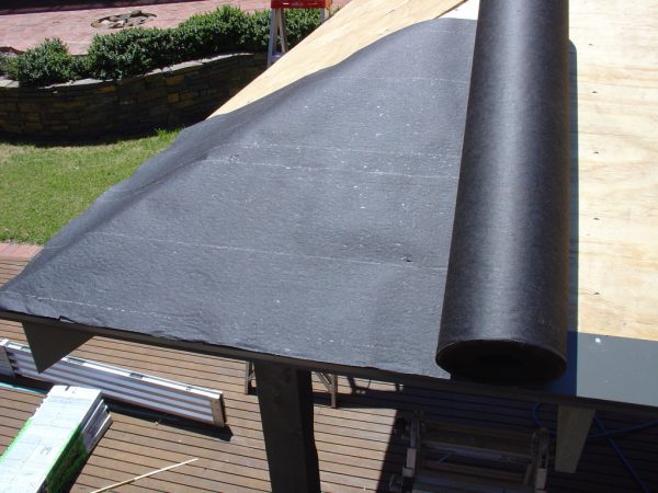Roll out the asphalt saturated felt material in line with the drip edge