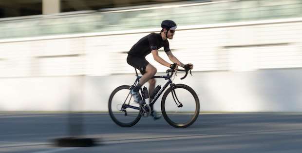 Cyclist riding fast as the background blurs