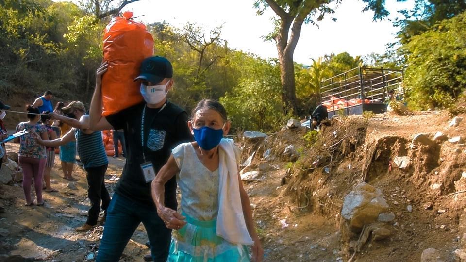 Joven ayuda a anciana en Gualán